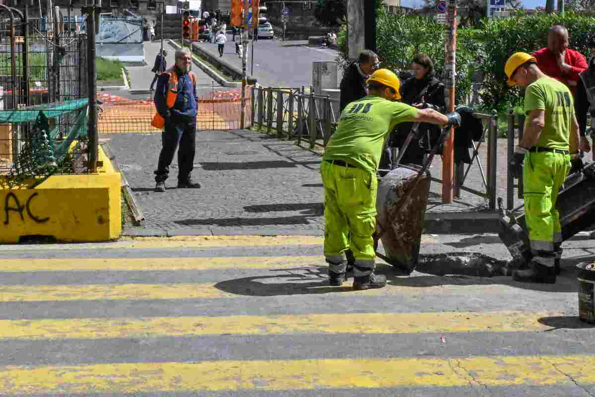 Giovani operai che lavorano per aggiustare una strada