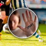 donna mostra il palmo della mano, su cui è scritto "stop"