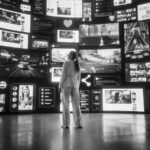 Ragazza guarda una parete con varie schermate tecnologiche